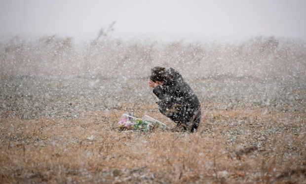 On the third anniversary of the Fukushima disaster a woman prays for those who died in the earthquake and tsunami in Rikuzentakata, Japan. Photograph: Kyodo/Reuters