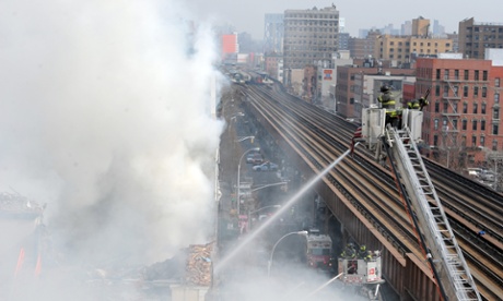 Firefighters battle a blaze at the site of an explosion and building collapse  in New York.