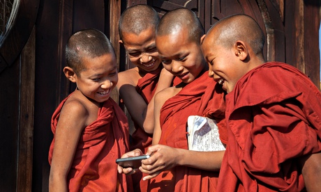 Young monks gathering around iphone
