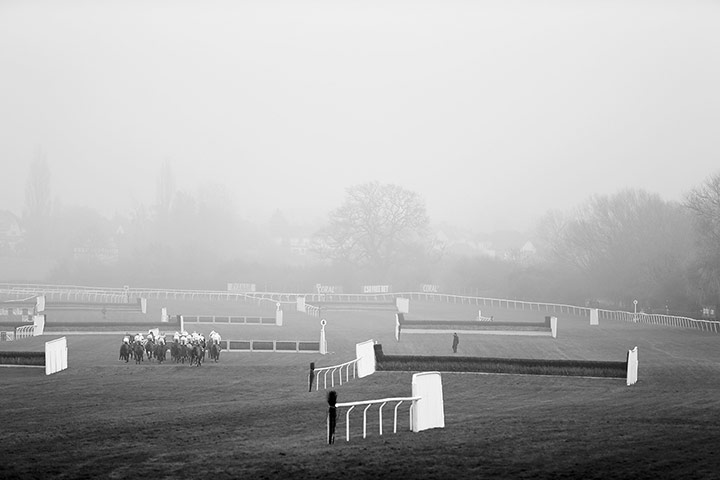 Cheltenham in b/w: Runners head into the fog 