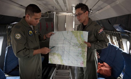 Royal Malaysian Air Force Navigator captain, Izam Fareq Hassan and pilot major Ahmad Shazwan Mohammed show locations on a map during a search and rescue operation to find the missing Malaysia Airlines flight MH370 plane over the Strait of Malacca.
