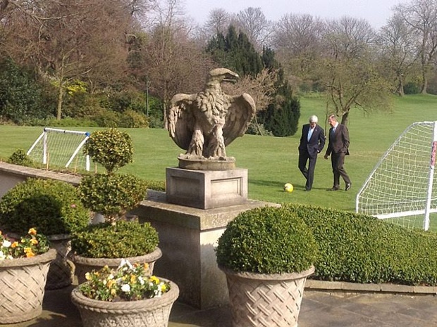 A photo made available by the Russian Foreign Ministry showing Kerry and Lavrov walking across the lawn at Winfield House during a break from the meeting room.