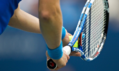 Detail of tennis player holding the racquet and ball about to serve.