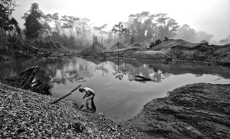 Rainforest: A gold miner washing in mercury mining pool