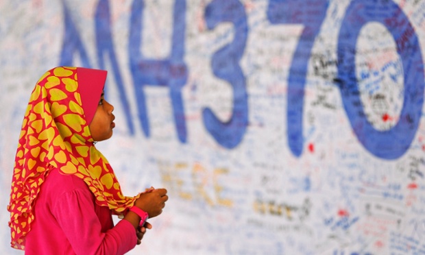 A girl looks at a board with messages of support and hope for passengers of the missing Malaysia Airlines plane at Kuala Lumpur international airport.