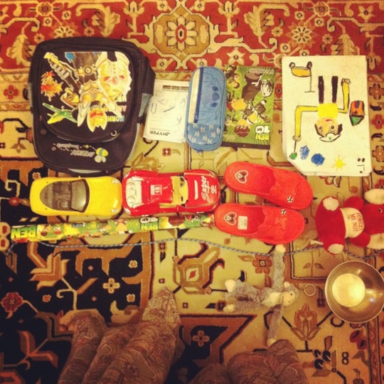 a ben 10 bag pencil case cars and sandals on a carpet