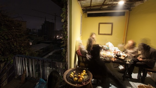 a group of people around a table eating dinner in the evening in tehran
