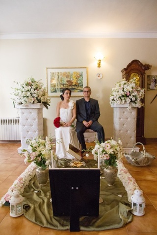 a bride and groom sitting amongst wedding decorations