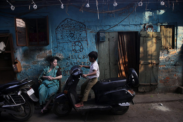 Tannery workers in India: A boy plays with a scooter near the leather goods workshop