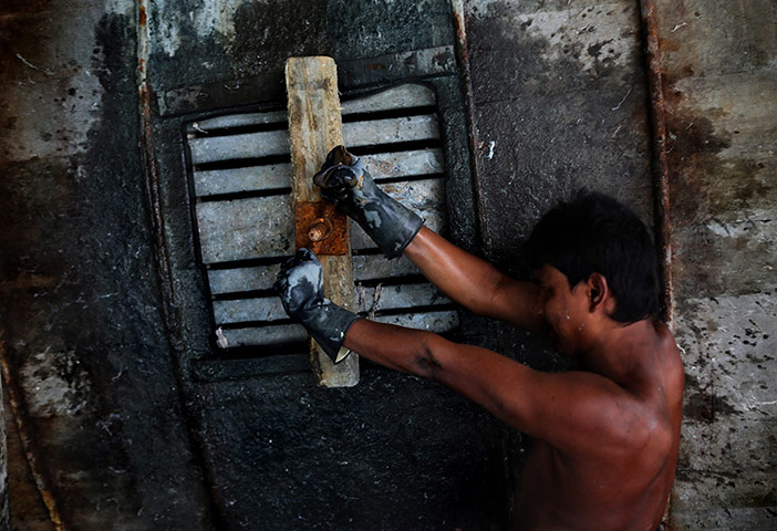 Tannery workers in India: Rafik Muhammad seals the opening to a huge leather treatment tank 