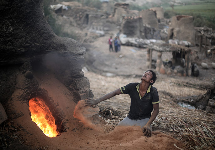 Egypt pottery: A man fans the flames of a kiln