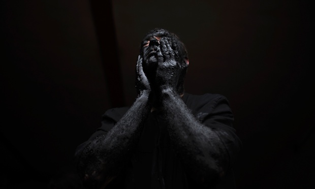 Luzon, Spain,: A man covers his face in oil and soot as he gets ready to start the carnival festival.