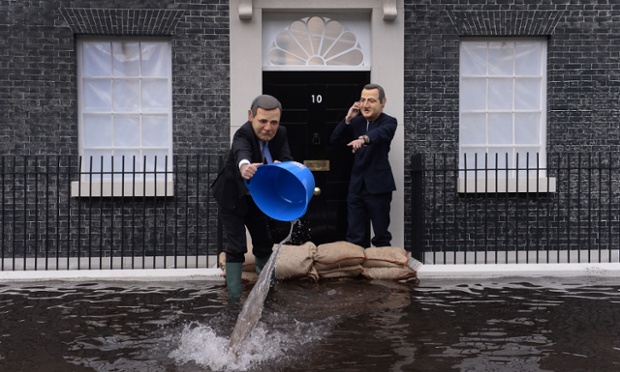 Drowning Street:  Campaigners dressed as Deputy Prime Minister Nick Clegg and Prime Minister David Cameron pose in front of a mock up of a flooded 10 Downing Street in London, to urge the Prime Minister to act on climate change.