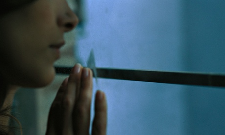 Woman looking out of window, close-up, cropped