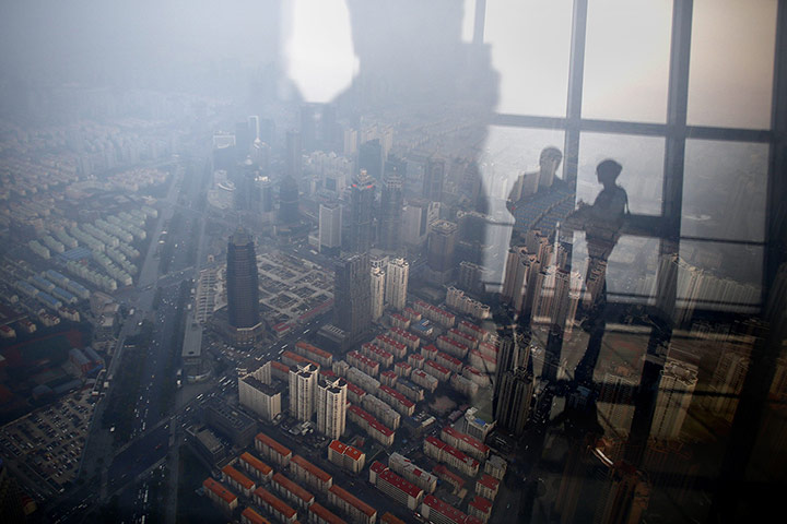 20 Photos: Men reflected in a window at the Pudong financial district in Shanghai