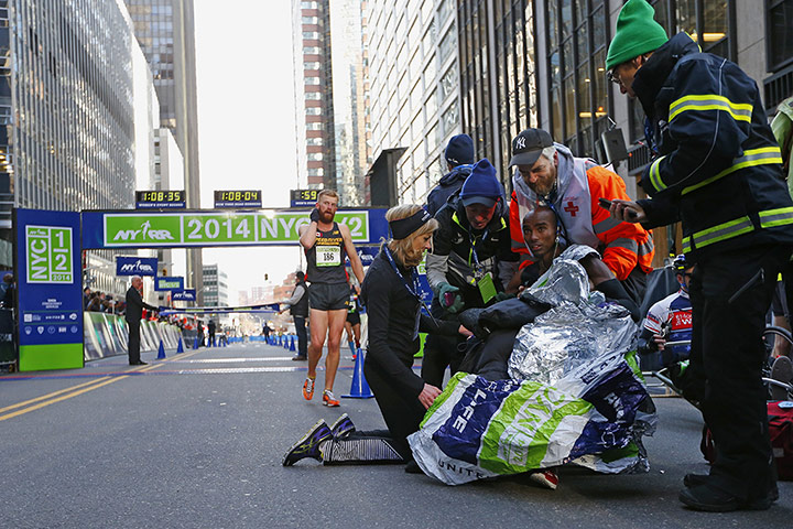 20 Photos: Mo Farah is helped up by medics at the 2014 New York City Half Marathon