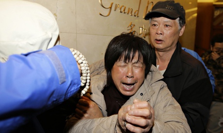 Relative of a passenger on MH370 cries after hearing the missing plane is assumed to have crashed