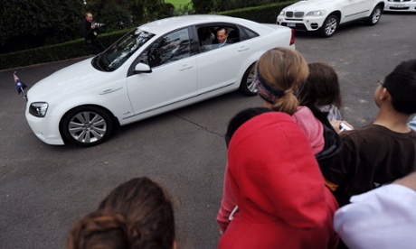 Prime Minister Tony Abbott greets students from Overnewton Anglican Community College in Keilor from his car after the farewell call on Governor-General Quentin Bryce at Government House in Canberra, Tuesday, March 25, 2014. Outgoing Governor-General Bryce will be farewelled in a ceremony later today.