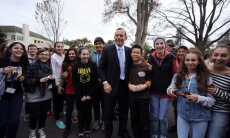 Prime Minister Tony Abbott poses for photographs with students from Overnewton Anglican Community College in Keilor after the farewell call on Governor-General Quentin Bryce at Government House in Canberra, Tuesday, March 25, 2014. Outgoing Governor-General Bryce will be farewelled in a ceremony later today.