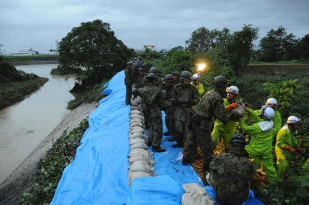 Japan Ground Self-Defence Force soldiers place sandbags to reinforce embankments on Shonai river 