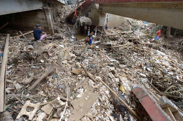 Men fish in the polluted Ciliwung river following heavy floods in Jakarta 