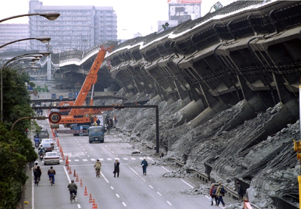 A giant crane pulls crushed cars out of the debris January 18 after the Hanshin Expressway was devastated during the worst earthquake in Japan