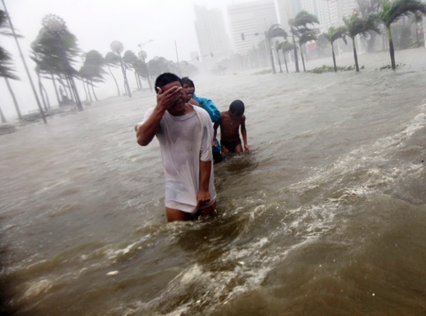 Filipinos wade through floodwaters along Roxas boulevard during Typhoon Nesat in Manila