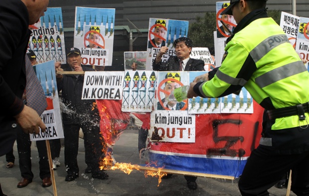 South Korean conservative protesters burn North Korea's flag during a rally in Seoul.