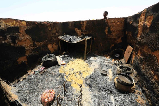 A man looks into a house that was burned down after an attack by rebels in Mellit town, North Darfur.