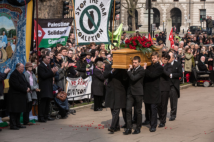 Tony Benn's funeral: Family members of Tony Benn carry his coffin past supporters holding banner