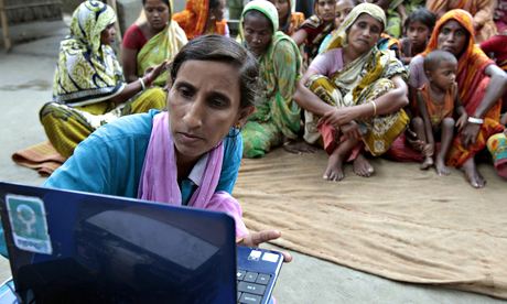 A Bangladeshi woman brings a laptop to a village to help people access the internet.