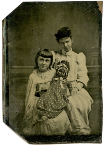 A tintype of a girl with a black doll and a woman, c1875.
