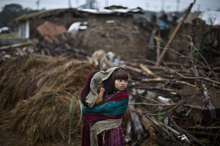 20 Photos: Two children look at mud houses of Afghan refugees near Islamabad