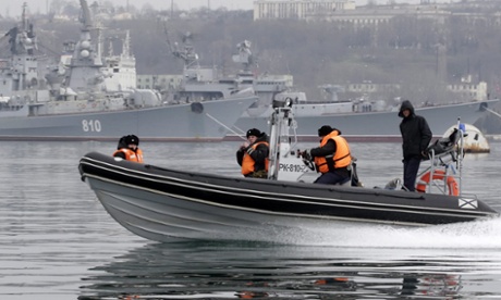 Russian navy crew members on a patrol boat guard the Russian military ships of the Black Sea Fleet with destroyers 'Smetlivyy' (back L) and 'Kerch' (back R) in the port of Sevastopol, Crimea, Ukraine, on 2 March 2014.