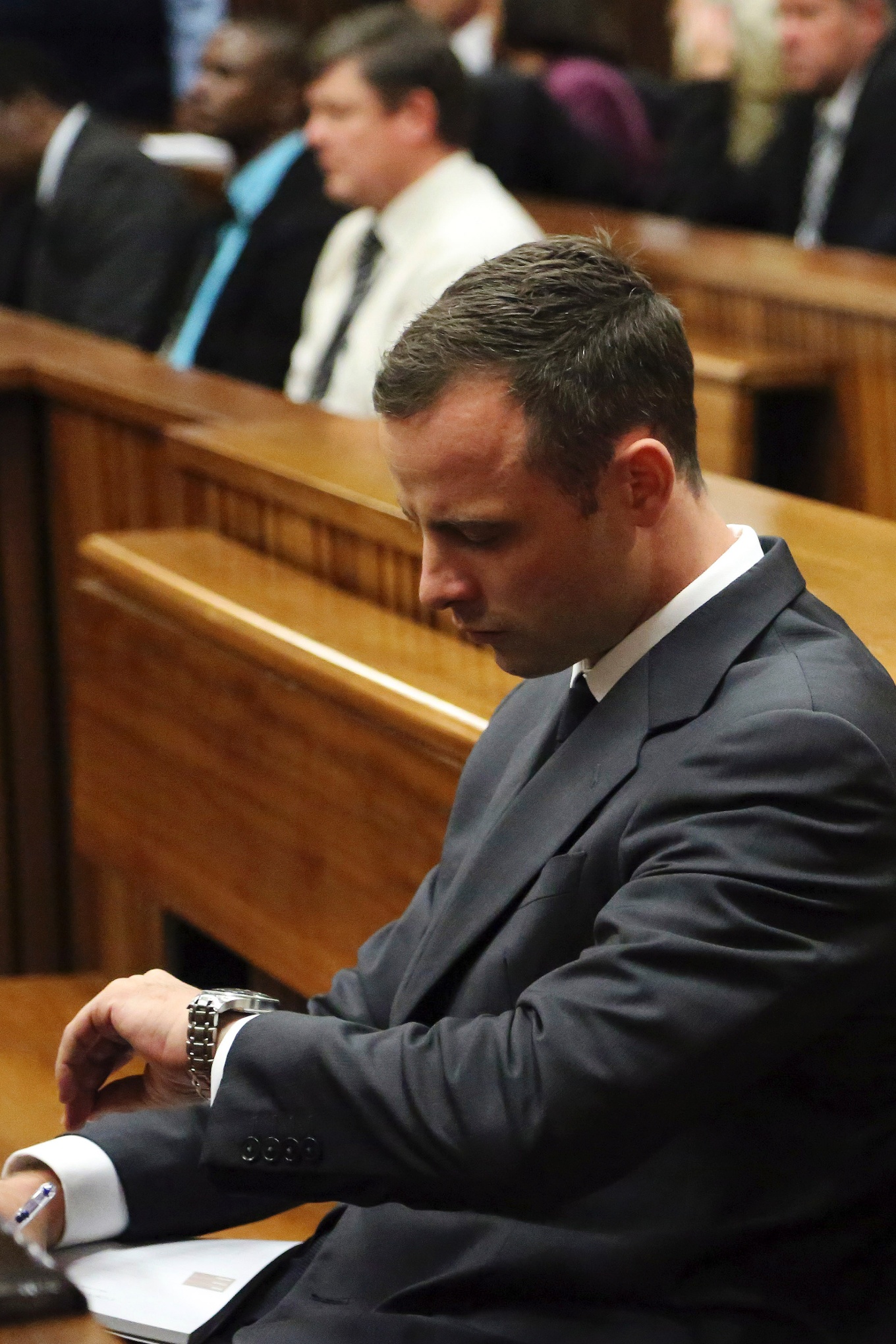 El atleta Oscar Pistorius observa su reloj mientras espera al juez el 3 de marzo de 2014.
