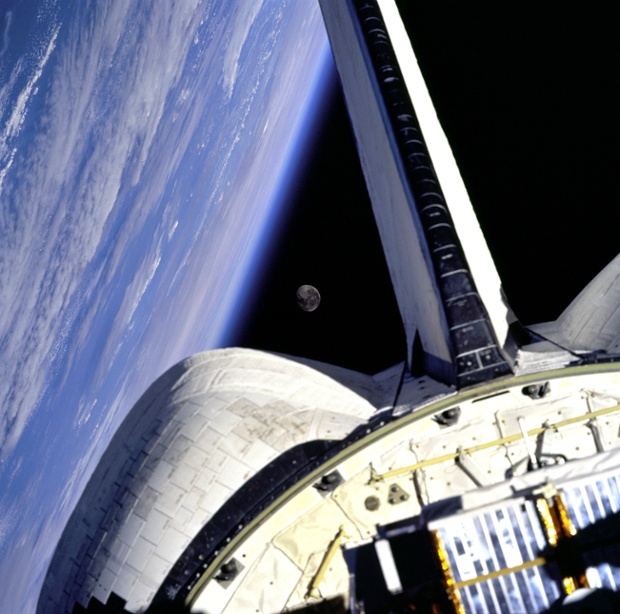Earth and its moon are nicely framed in this image taken from the aft windows of the space shuttle Discovery in 1998. Discovery - on mission STS-95 - was flying over the Atlantic Ocean at the time