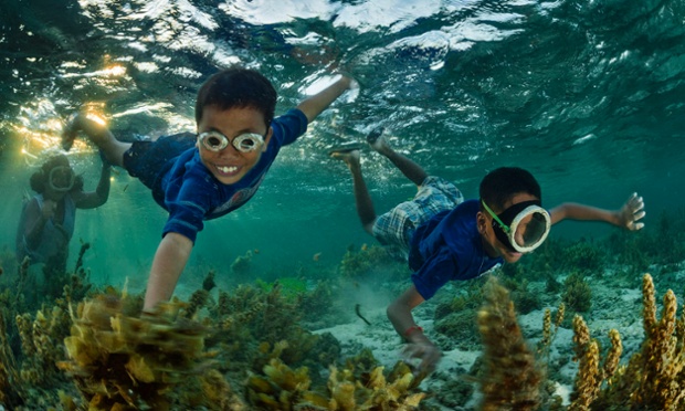 Marven Jay and his friends collecting nudibranch eggs for dinner  during the low tide in the sea beds around Bilang bilangan island.