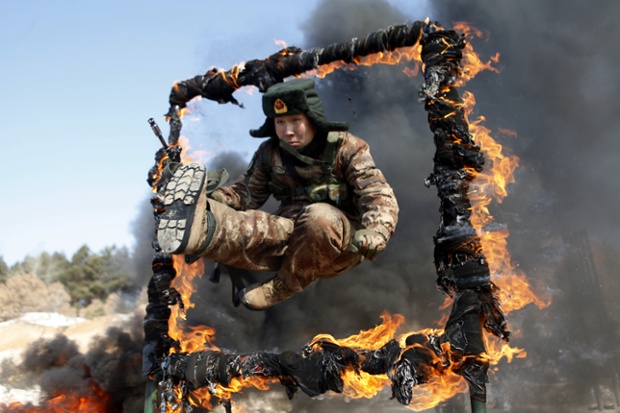 Blasé about the blaze: a soldier jumping over a ring of fire during a tactical training mission in Heihe,  China.