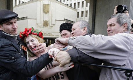A Femen protester against Putin's policy concerning Ukraine is detained near Crimea's parliament