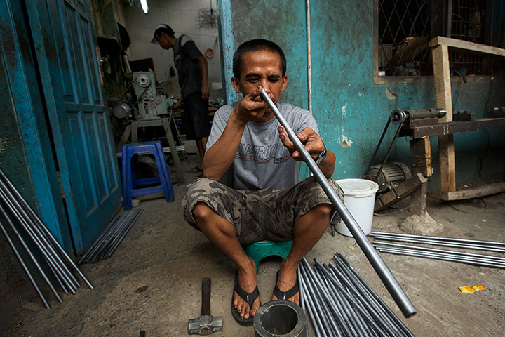 Air rifle capital: A gunsmith checks the bore of a rifle barrel in a small air rifle factory