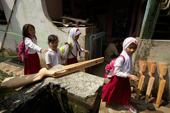 Air rifle capital: Schoolchildren pass air rifle stocks laid out to cure 