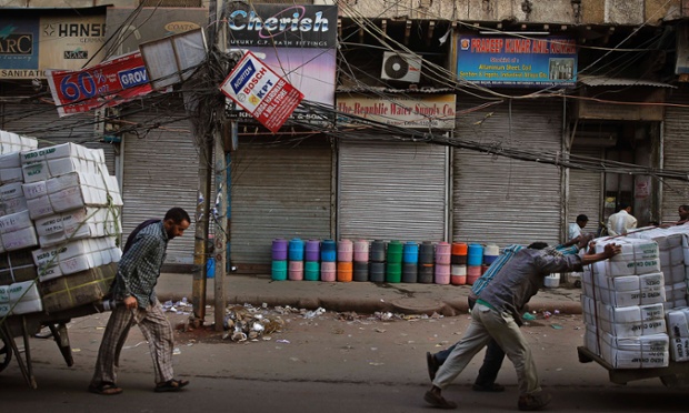 Push me - Pull me: Indian labourers move carts in New Delhi, India,.
