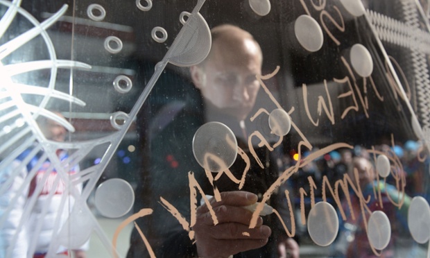 Russian President Vladimir Putin puts his signature upon a board as he visits the mountain Paralympic village outside Sochi as Russia opens its first ever Winter Paralympics in the Black Sea resort.