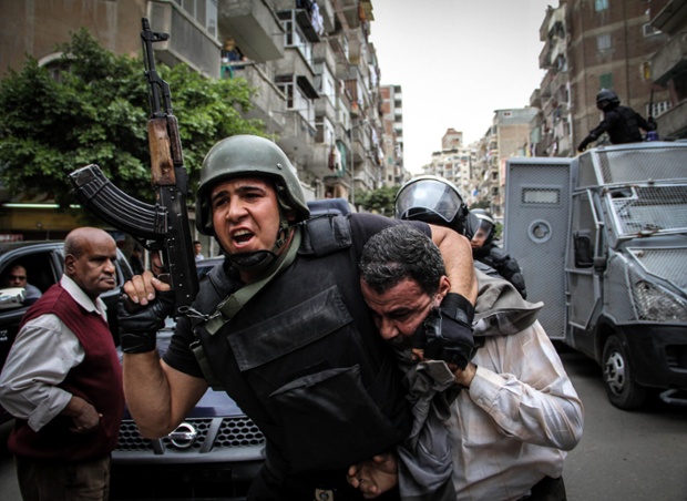 Egyptian security forces in Alexandria detain demonstrator as Egyptians gather to protest against the deposing of former President Morsi.