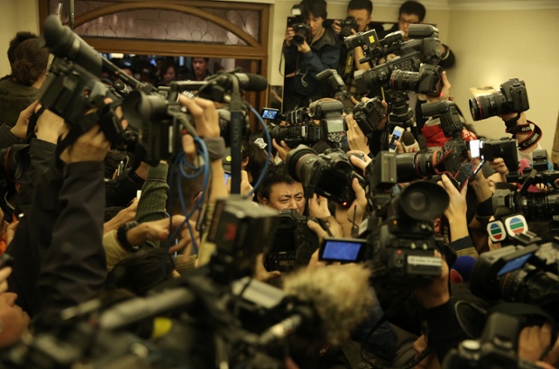 A relative of a passenger on the missing Malaysia Airlines flight MH370 is surrounded by the media at Lidu hotel in Beijing, China