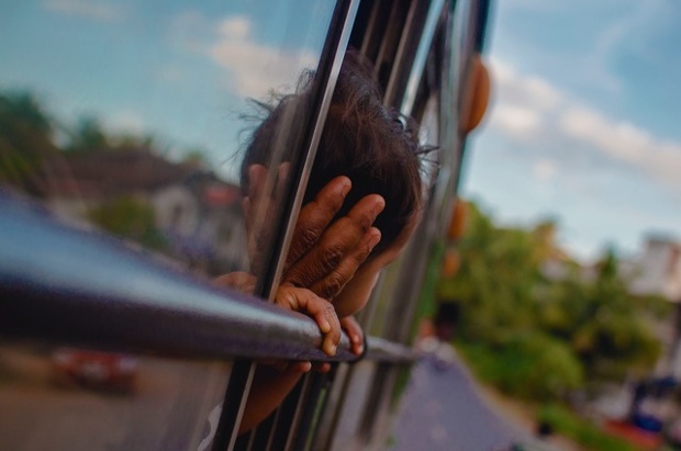 'A child looking out of the bus.'