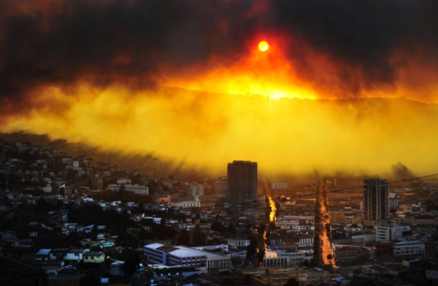 Sunlight breaks through smoke from a forest fire in Valparaiso, Chile.