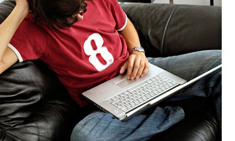 Teenage boy uses laptop