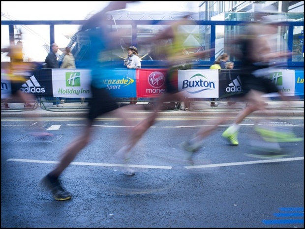 Runners passing rapidly through the Canary Wharf stretch of the London marathon