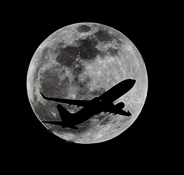 A plane crosses the moon's path over Whittier, California, approximately one hour before the total lunar eclipse.